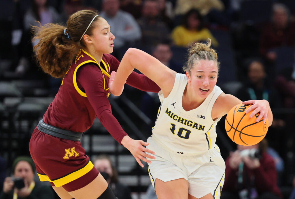 Michigan's Jordan Hobbs dribbles the ball around Minnesota's Amaya Battle during the 2024 NCAA basketball game.